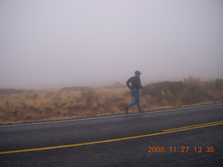 318 6pt. Canyonlands National Park - Lathrop trail hike - Adam running on the road in the rain